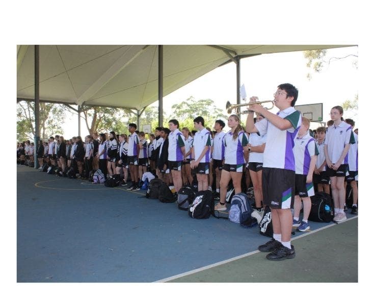 Students standing whilst the bugle is played at ANZAC day service